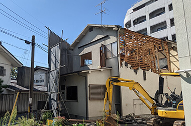 木造住宅を重機を使って解体している様子